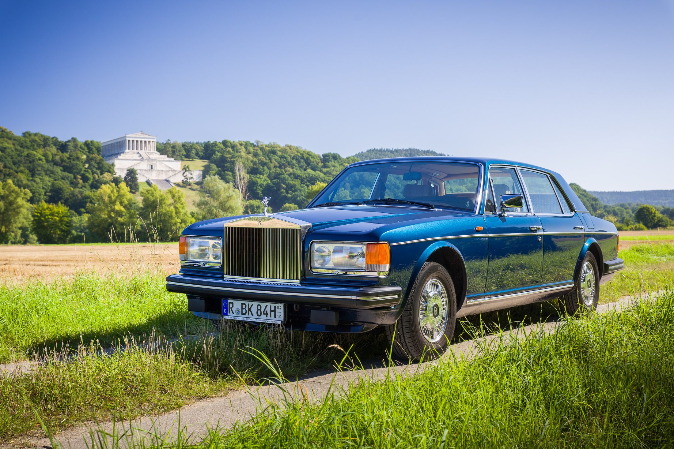 Rolls-Royce Silver Spur auf einer Wiese, im Hintergrund ein Schloss