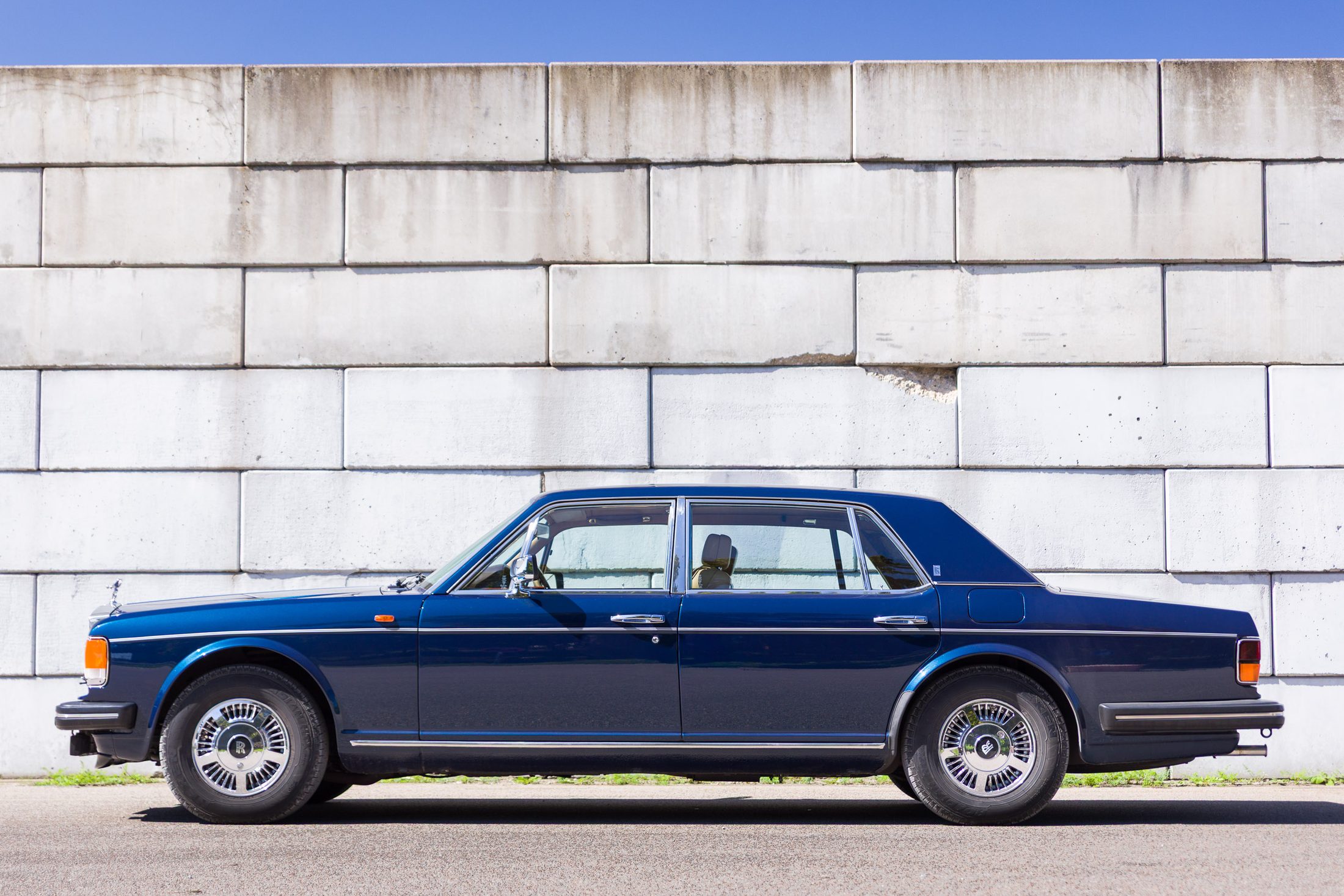 Rolls-Royce Silver Spur im Seitenprofil vor einer Steinmauer